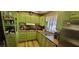Bright kitchen with green cabinets, stainless steel appliances, and wood-look flooring at 351 Bunarch Rd, Pahrump, NV 89060