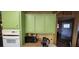 White appliances and green cabinets in this bright kitchen at 351 Bunarch Rd, Pahrump, NV 89060