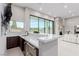 Wet bar featuring marble countertops, dark wood cabinetry, stainless steel beverage fridge, and sliding glass doors to outdoors at 7062 Maverick St, Las Vegas, NV 89131