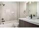 Modern bathroom features a white tiled tub, stylish vanity with dark wood cabinets, and sleek fixtures at 7062 Maverick St, Las Vegas, NV 89131