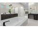 Beautiful bathroom features dual sink vanity, soaking tub with black faucet, and large mirrors with pendant lights at 7062 Maverick St, Las Vegas, NV 89131