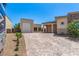 Spacious driveway leading to a home with stone accents, a garage, and mature landscaping at 7062 Maverick St, Las Vegas, NV 89131