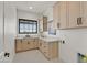 Bright laundry room with ample cabinetry and a window at 9880 Dorrell Ln, Las Vegas, NV 89149
