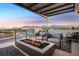 Covered patio with fire pit and comfortable seating, offering mountain views at 9880 Dorrell Ln, Las Vegas, NV 89149