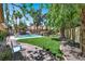 Landscaped backyard with a path, lawn, and a rock waterfall feature at 1813 Skyline Dr, Las Vegas, NV 89117