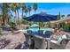 Outdoor patio with dining table and chairs, umbrellas, and lush landscaping at 1813 Skyline Dr, Las Vegas, NV 89117