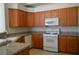 Kitchen with wood cabinets, granite countertops and white appliances at 4727 Wild Draw Dr, North Las Vegas, NV 89031