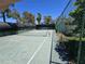 Outdoor tennis court surrounded by a chain link fence and mature trees, offering a private recreational space at 5906 El Parque Ave, Las Vegas, NV 89146