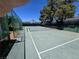 Outdoor tennis court surrounded by a chain link fence and mature trees, offering a private recreational space at 5906 El Parque Ave, Las Vegas, NV 89146