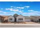 Charming home featuring a brick driveway, three gables, and a two-car garage, all under a bright, partly cloudy sky at 7132 Silver Palace St, Las Vegas, NV 89131