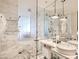 Sleek bathroom featuring marble tiles, dual vanities, a glass-enclosed shower, and modern fixtures at 4381 W Flamingo Rd # 1905, Las Vegas, NV 89103