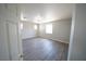 Bedroom features multiple windows, wood-look flooring, and a door with gold hardware at 5713 Heineken Dr, North Las Vegas, NV 89031