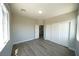 Spacious bedroom with wood-look floors, natural light, and a closet for storage at 5713 Heineken Dr, North Las Vegas, NV 89031