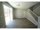 Bright living space with sliding glass doors, staircase, and wood-look flooring at 5713 Heineken Dr, North Las Vegas, NV 89031