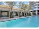 Beautiful swimming pool featuring shaded cabanas, mature landscaping, and a view of the modern building at 4471 Dean Martin Dr # 2205, Las Vegas, NV 89103