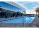 Relaxing swimming pool with lounge chairs surrounded by mature landscaping and a modern building facade at 4471 Dean Martin Dr # 2205, Las Vegas, NV 89103