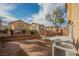 View of the gravel backyard featuring low block wall and access to other homes in the community at 1161 Gecko Rd, Henderson, NV 89002