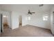 A bright bedroom with carpet floors, a ceiling fan, and a door to the bathroom at 1161 Gecko Rd, Henderson, NV 89002