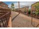 Shared, gravel backyard space between the houses, lined with palm trees and fencing at 1161 Gecko Rd, Henderson, NV 89002