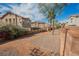 View of the community backyard space behind the houses, featuring palm trees and gravel at 1161 Gecko Rd, Henderson, NV 89002