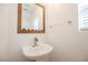 Bright half-bath features a vessel sink, modern faucet, framed mirror and window at 1161 Gecko Rd, Henderson, NV 89002