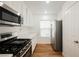 Modern kitchen with white cabinets, stainless steel appliances, and wood-look flooring at 1161 Gecko Rd, Henderson, NV 89002