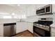 Kitchen with stainless steel appliances, white cabinetry, and open floor plan at 1161 Gecko Rd, Henderson, NV 89002