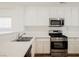 Bright kitchen with white cabinets, stainless steel appliances, and quartz countertops at 1161 Gecko Rd, Henderson, NV 89002
