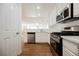 Kitchen with stainless steel appliances, white cabinets, and open view to living area at 1161 Gecko Rd, Henderson, NV 89002
