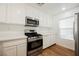 Bright kitchen featuring white cabinets, stainless steel appliances, and wood-look floors at 1161 Gecko Rd, Henderson, NV 89002