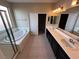 Bright bathroom featuring double sinks, a soaking tub, and a separate glass-enclosed shower at 7421 Old Compton St, Las Vegas, NV 89166