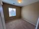 A tidy, carpeted bedroom featuring a bright window with blinds and neutral walls awaiting décor at 7421 Old Compton St, Las Vegas, NV 89166