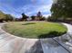 Expansive grassy community park with walking path, mature trees, and clear blue sky at 7421 Old Compton St, Las Vegas, NV 89166