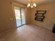 Bright dining area with tile flooring, a modern chandelier, and sliding glass doors to the patio at 7421 Old Compton St, Las Vegas, NV 89166