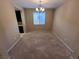 Well-lit dining room featuring neutral carpet, a chandelier, and a large window at 7421 Old Compton St, Las Vegas, NV 89166