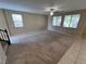 Spacious living room featuring neutral walls, carpet flooring, ceiling fan and natural light at 7421 Old Compton St, Las Vegas, NV 89166