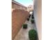 A cozy side yard with stone pavers, tidy bushes, and a sturdy brick wall offering privacy at 7421 Old Compton St, Las Vegas, NV 89166