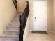 Carpeted staircase with black banister leading to the upper floor and front door at 7421 Old Compton St, Las Vegas, NV 89166