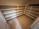 Spacious walk-in closet with ample shelving and neutral tile flooring, ready for organization at 7421 Old Compton St, Las Vegas, NV 89166