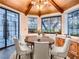 Bright dining area with ample windows and built-in wooden cabinets and shelves, complemented by a wood table and white chairs at 1 Quail Run Rd, Henderson, NV 89014