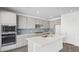 Modern kitchen with island, gray cabinets, and blue tile backsplash at 106 Via Franello, Henderson, NV 89011