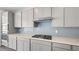 Modern kitchen with gray cabinets, stainless steel appliances, and blue tile backsplash at 106 Via Franello, Henderson, NV 89011