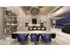 Elegant dining area with a large table, modern chairs, a statement chandelier, and a wine cellar nearby at 616 Scenic Rim Dr, Henderson, NV 89012