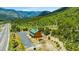 Aerial shot of a wooden building with a green roof among rolling hills and a mountain backdrop at 4205 Mont Blanc Way, Las Vegas, NV 89124