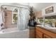 Bright bathroom boasts a tub with shower, natural light, and granite countertop at 4205 Mont Blanc Way, Las Vegas, NV 89124