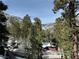 Exterior view of a log cabin home nestled among snowy trees with mountain views in the background at 4205 Mont Blanc Way, Las Vegas, NV 89124