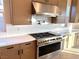 Gas cooktop, stainless steel hood, and custom cabinetry at 5569 Artex Ave, Las Vegas, NV 89139