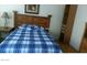 Bedroom with a bed with a blue and white checked sheet and a wooden headboard at 1707 Santa Paula Dr, Las Vegas, NV 89104