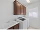 Laundry room featuring chocolate cabinets over a white washer and dryer, and a large sink at 3179 Surf Spray St, Las Vegas, NV 89117