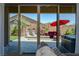 View of backyard through sliding glass doors; fire pit, hot tub, patio furniture at 3870 Valles Caldera Ct, Las Vegas, NV 89118